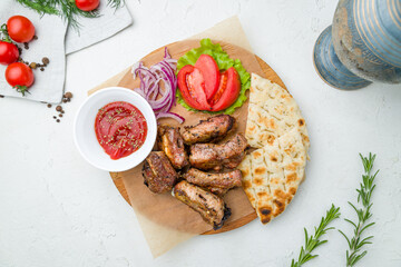 skewers of pork ribs with vegetables, pita and totamo sause