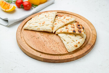 Greek pita on the board on white concrete table