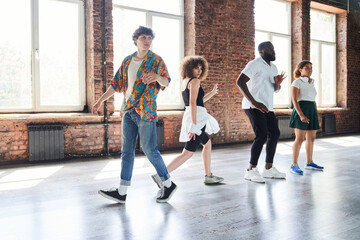 Jolly young people enjoying dancing together indoors