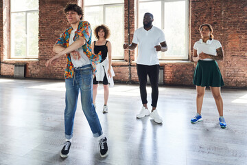 Fototapeta premium Cheerful young male teaching group of hip-hop