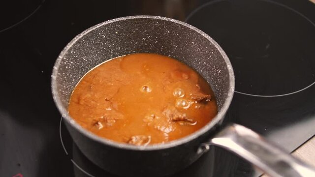 cooking beef goulash.Induction cooking beef goulash in a pot for induction.4K Video motion.