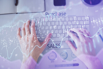 Double exposure of man's hands typing over laptop keyboard and forex chart hologram drawing. Top view. Financial markets concept.