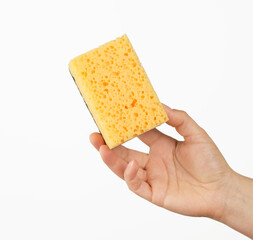 female hand holds a yellow kitchen sponge for washing dishes