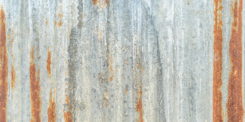 Corrugated galvanized rusty metal sheet background with old aged rust texture on zinc tin or iron steel grunge wall roof panel for vintage wallpaper 