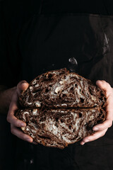 Vegan chocolate bread in hands of baker. Gluten-free and without animal products.