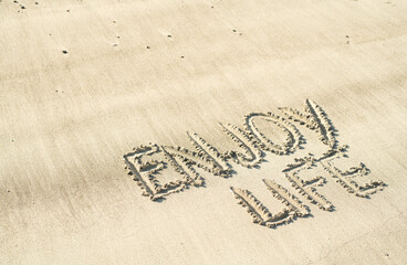 enjoy life hanschriftlich in den Sand geschrieben 