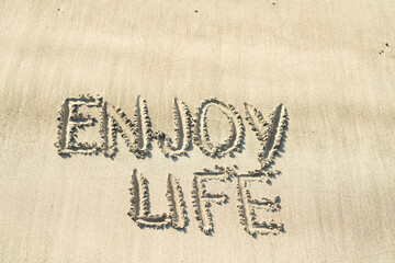 enjoy life hanschriftlich in den Sand geschrieben 