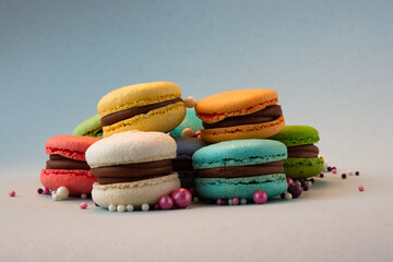 Multicolored macarons with beads on a gray background.