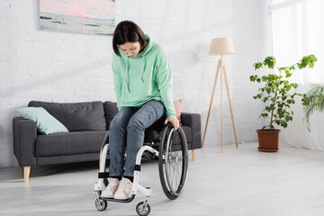 Pretty woman in wheelchair exercising at home