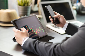 Business man use digital tablet.pointing device screen and holding smart phone on desk at home office ,Work from Home business and technology concept