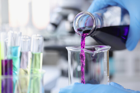 Scientist Chemist Pouring Pink Liquid Into Test Tube In Lab Closeup