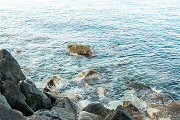 Steinküste Gran Canaria bei Sonnenaufgang und ruhiger See mit leichtem Wellengang
