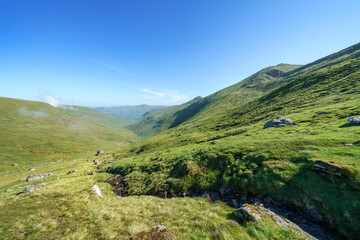 The valley, glen, of Allt a Chobhair below the summits of An Stuc and Ben Lawers with Carn Gorm off in the distance in the Scottish Highlands, UK landscapes.