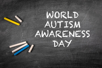 World Autism Awareness Day 2 April. Colored pieces of chalk on a dark blackboard background