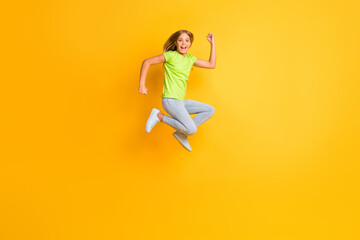 Fototapeta na wymiar Full length profile side photo of young excited girl happy positive smile crazy rejoice jump up isolated over yellow color background