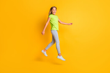 Fototapeta na wymiar Full body profile side photo of young girl happy positive smile go walk jump up isolated over yellow color background