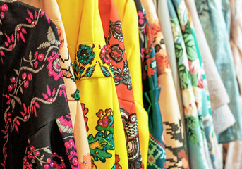 Bright dresses with national Russian ornaments on the store counter.