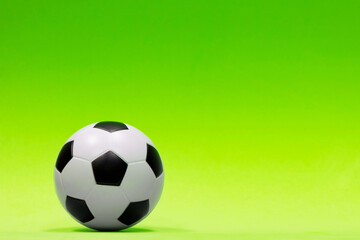 Obraz premium Soccer ball isolated against a plain green background with gradual color shading. Conceptual image with copy space on the right side.