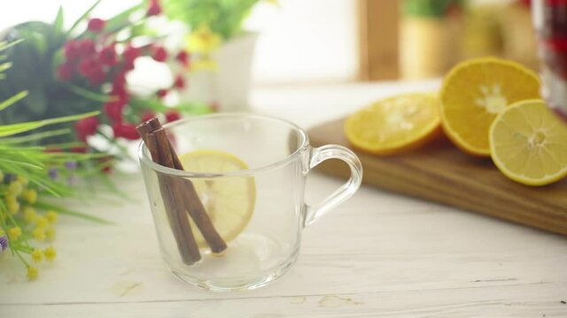 Tea is poured into a glass transparent cup on a wooden table