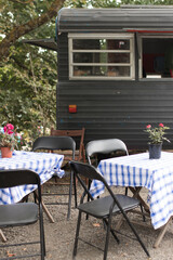 table chairs blue white tablecloth picnic rustic caravan food truck cafe outdoors cute eat restaurant