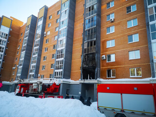 a fire engine and people in the courtyard of an apartment building extinguish a fire in an apartment in an apartment building