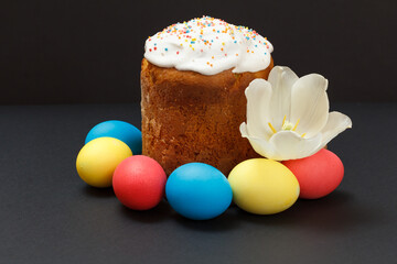 Easter cake and colored Easter eggs with tulip flower bud.