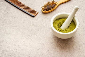 Henna hair dye powder and wooden comb. Henna in wtite mortar