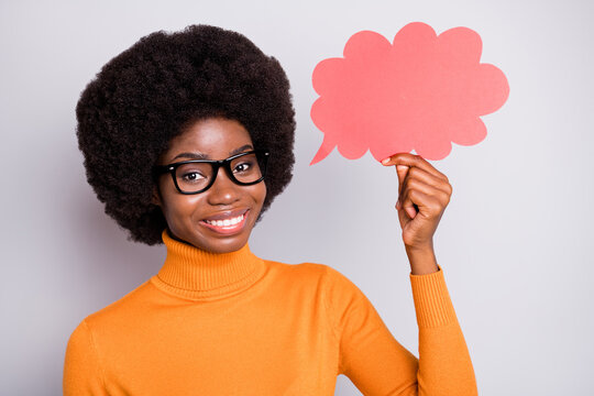Photo portrait of afro american woman holding pink speech bubble card in one hand isolated on clear grey colored background