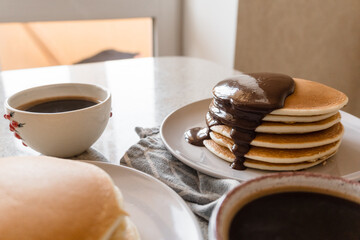 two plates with stacks of pancakes