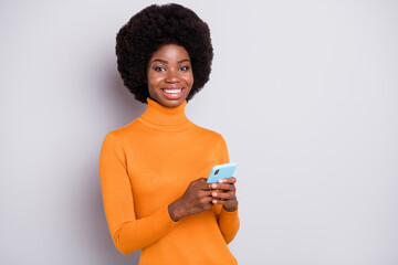 Photo of young cheerful afro girl happy smile use smartphone chat browse internet isolated over grey color background