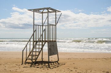 Empty old lifeguard tower on the beach on a cloudy day. Security on public and private beaches.