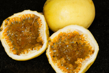 Passion fruit cut to make a juice with a black granite background.