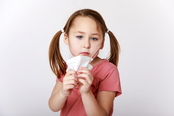 Girl taking away a medical mask to breathe better