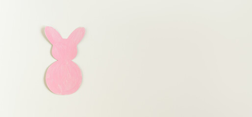 Easter pink paper bunny on the white background. Banner size.