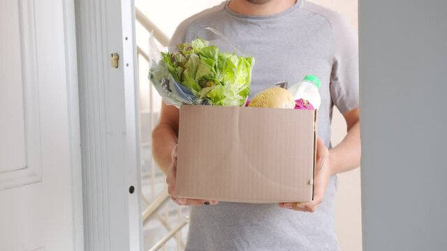 Delivery. Large cardboard box with ordered fresh vegetables and foods closeup.