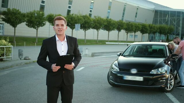 Sales salesman consultant with folder in his hand in suit sells car. Selects