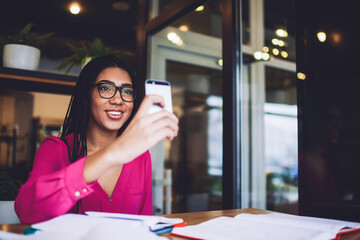 Satisfied African American woman with smartphone in cafe