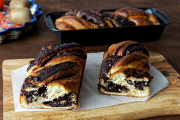 Braided cake with chocolate cut in half. Yeast-risen dough twisted krantz cake.