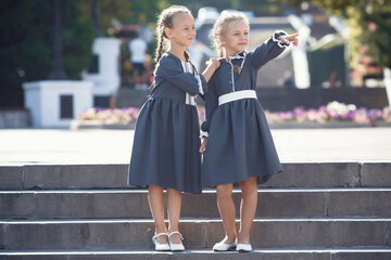 Charming little girls in retro dress walking in town on a sunny summer day