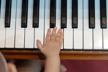 Baby Girl's Right Hand Playing with Piano Keys