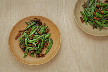 Two plates with stir-fry five-spice sugar snap peas tofu. Flat lay, top view.