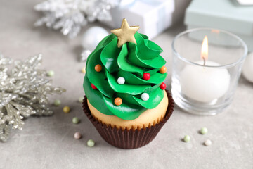Christmas tree shaped cupcake on light grey table, closeup
