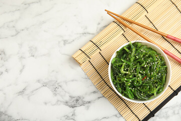 Japanese seaweed salad served on white marble table, flat lay. Space for text © New Africa