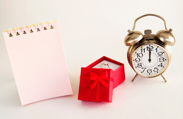 Red box of special gifts with a ring and a clock on a light background with a place for an inscription. concept of special gifts for special moments.