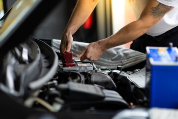 Auto mechanic worker checking and changing car battery. Car maintenance and auto service garage concept.