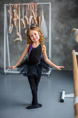 little girl ballerina in a black tutu at the machine
