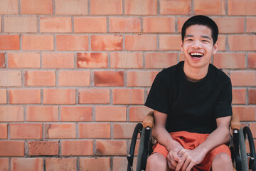 Fototapeta na wymiar Portrait of Asian special child on wheelchair is smiling face as happiness on orange brick wall at the house, Lifestyle in the education age of disabled children, Happy disability kid concept.