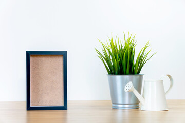 black square frames and green plant on wooden table,