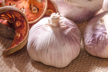 Top view of dry bael fruit tea and garlic on the sackcloth in the kitchen. Thai herb and asian ingredients for cooking, Design for food stylist work.