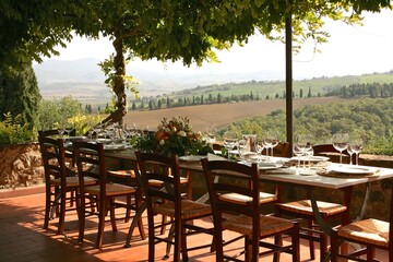 Fototapeta na wymiar Table set for al fresco dinner with a view. Tuscany, Italy 